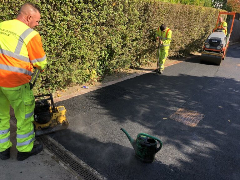 Hazell & Jefferies employees in high-viz, repairing an asphalt driveway.