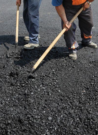 Hazell & Jefferies team members preparing a road resurface with shovels