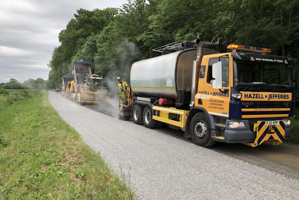 Hazell & Jefferies surface dressing lorry laying down surfacing material on a road.